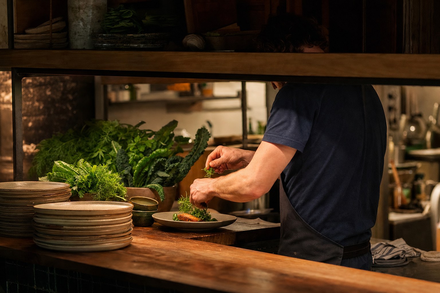 Chef finishing a seasonal dish at the kitchen pass
